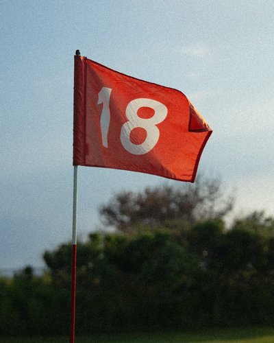 Rote Fahne mit der Zahl 18 auf einem Golfplatz