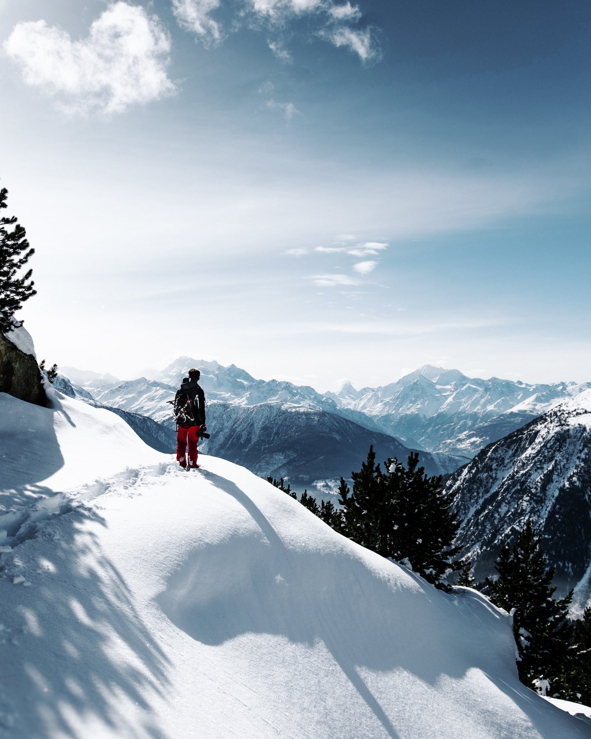 Wunderbares Winterwandern in Lermoos Person in roter Hose wandert durch schneebedeckte Berge bei klarem Himmel