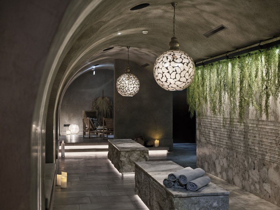 Wellness und Luxus: Ihr Hotel in Tirol Ruhebereich mit Steinliegen, schönen Lampen und Pflanzenwand im Spa