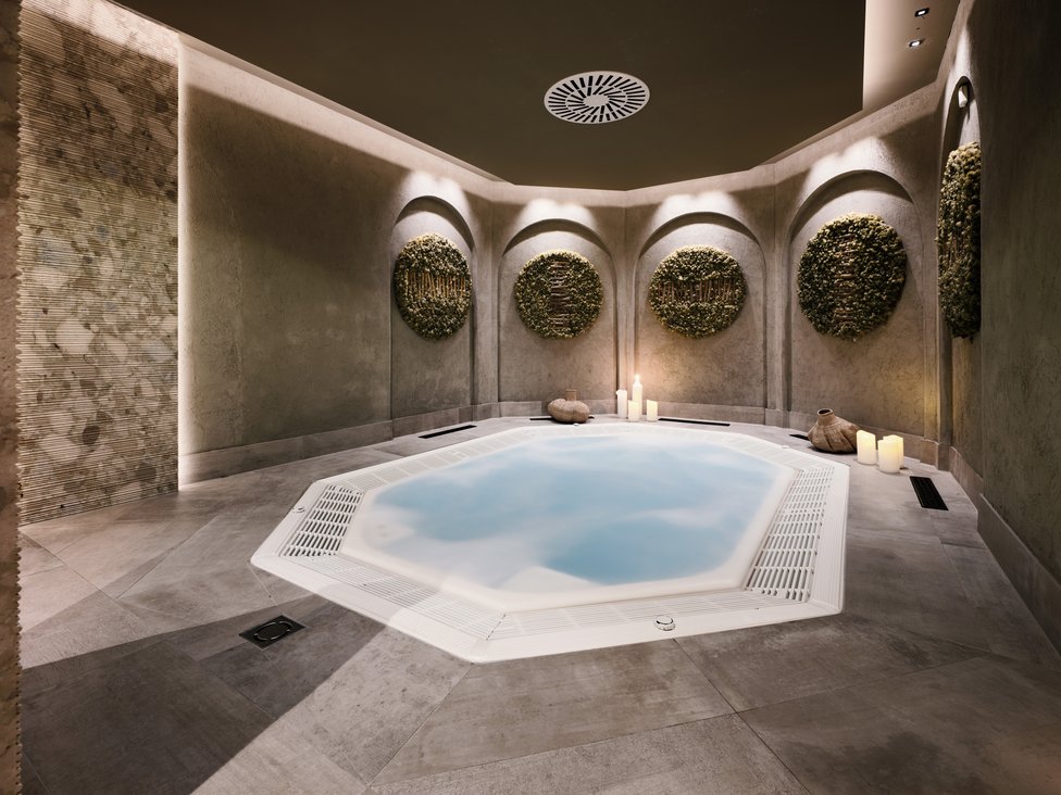 Moderner Wellnessbereich mit beleuchtetem Whirlpool und Wanddekorationen