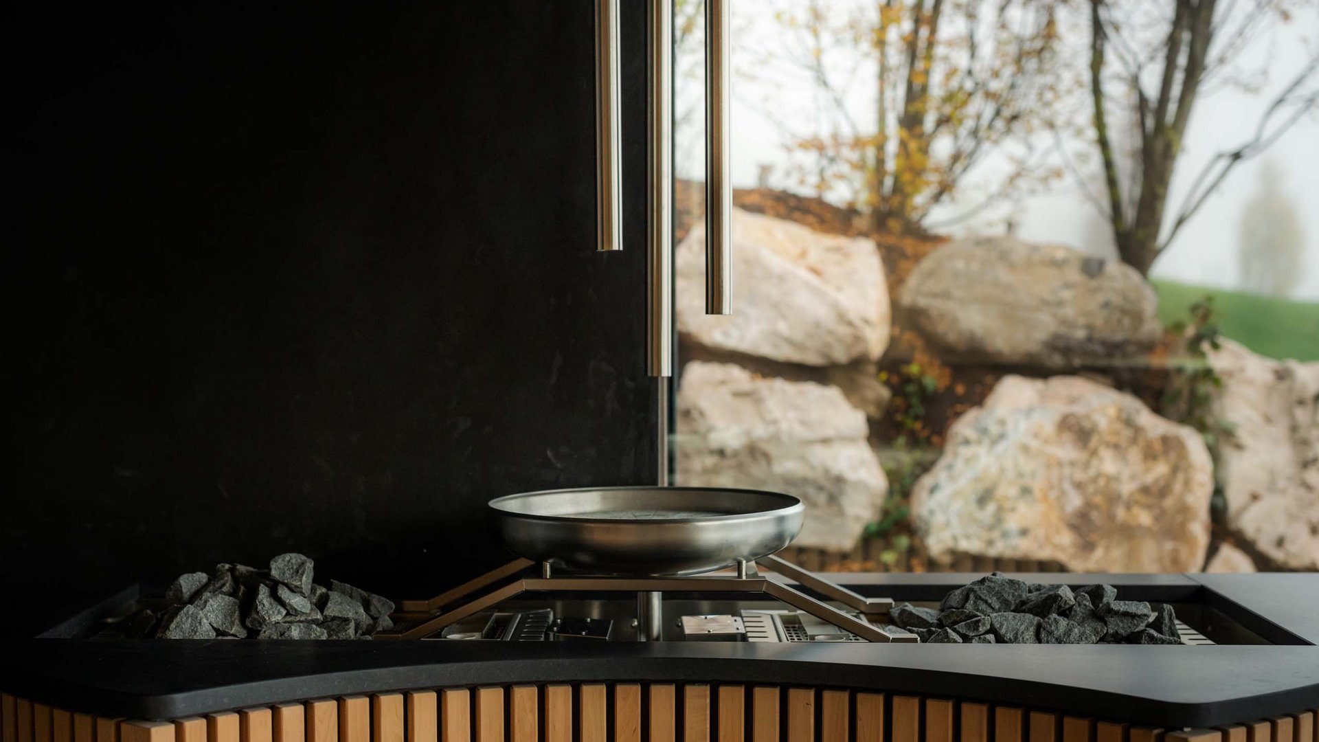 moderner holzofen mit sichtfenster und außenlandschaft im hintergrund