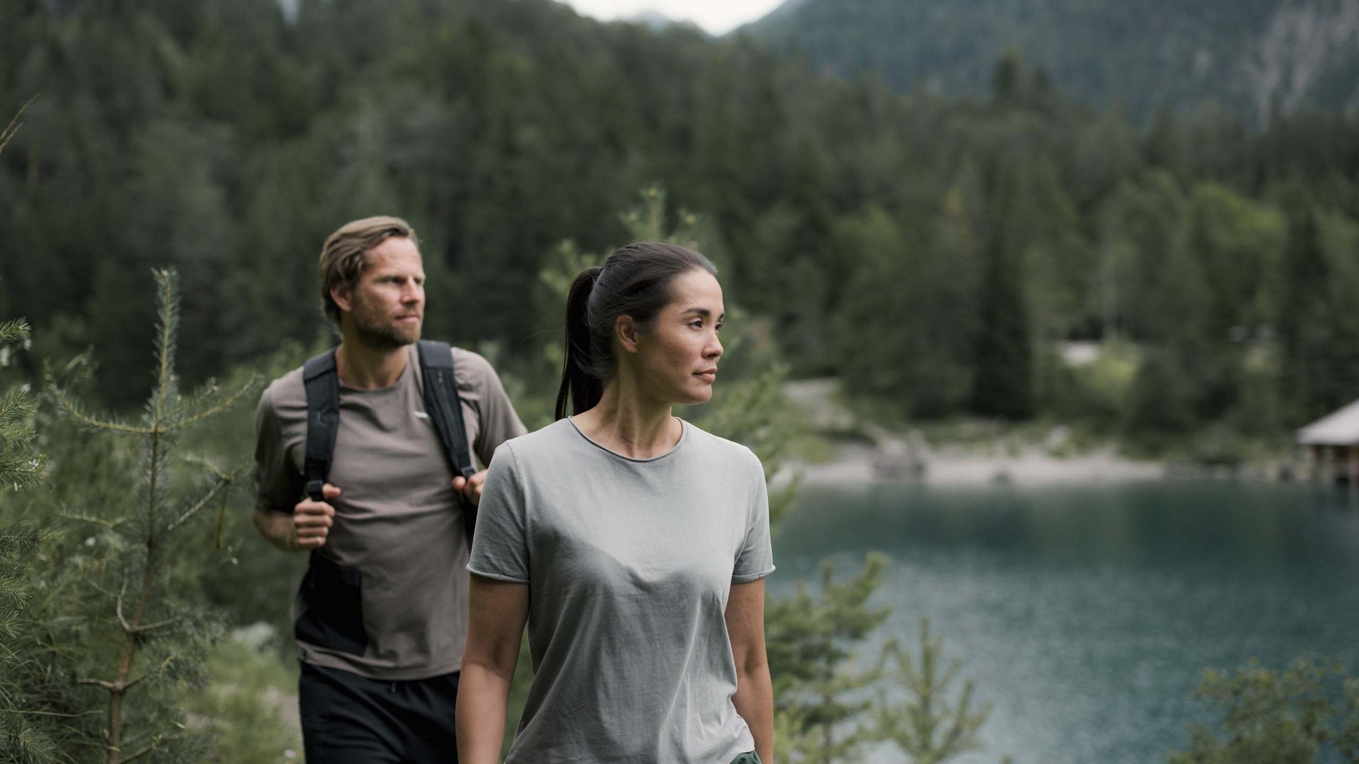 Wandern in und rund um Lermoos Zwei Wanderer auf einem Pfad nahe einem Bergsee umgeben von Wald