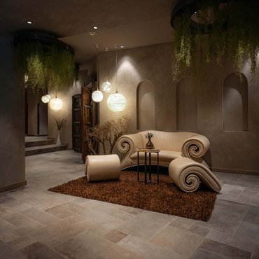 Elegantes Wohnzimmer mit einzigartigem Sofa, Teppich und hängenden Pflanzen