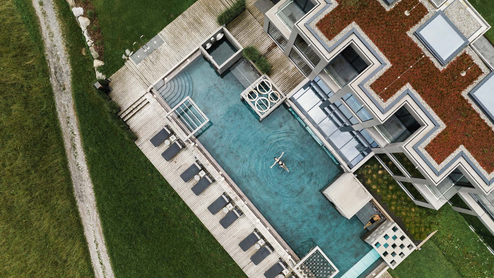 Vogelperspektive auf ein modernes Gebäude mit Außenpool und Grünfläche