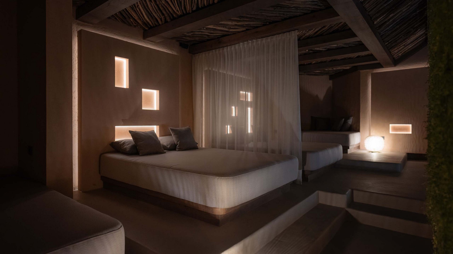 Gemütliches Schlafzimmer mit weicher Beleuchtung und Holzdecken