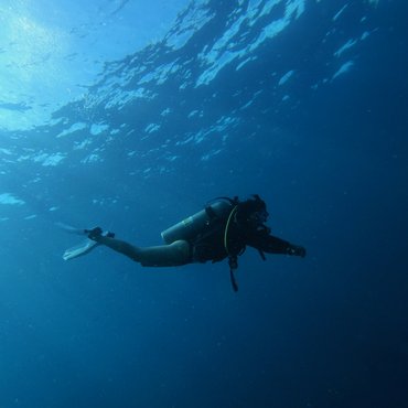 Taucher schwimmt unter Wasser mit Schnorchelausrüstung