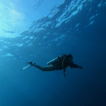 Taucher schwimmt unter Wasser mit Schnorchelausrüstung