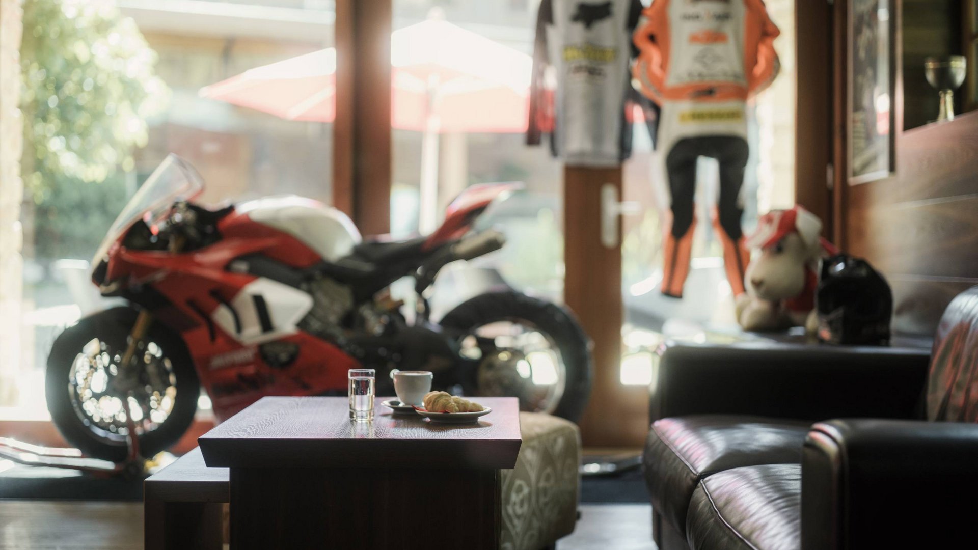 Sportmotorrad in Wohnzimmer mit Kaffee und Croissant auf Tisch
