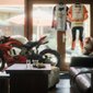 Sportmotorrad in Wohnzimmer mit Kaffee und Croissant auf Tisch