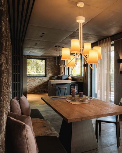 Wellness and luxury: your hotel in Tyrol Modern dining room with wooden table and large windows overlooking mountains