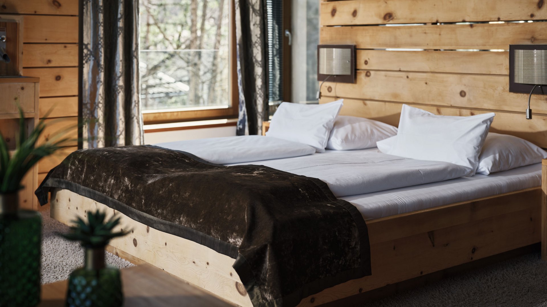 Gemütliches Schlafzimmer mit Holzmöbeln und großer Fensterfront