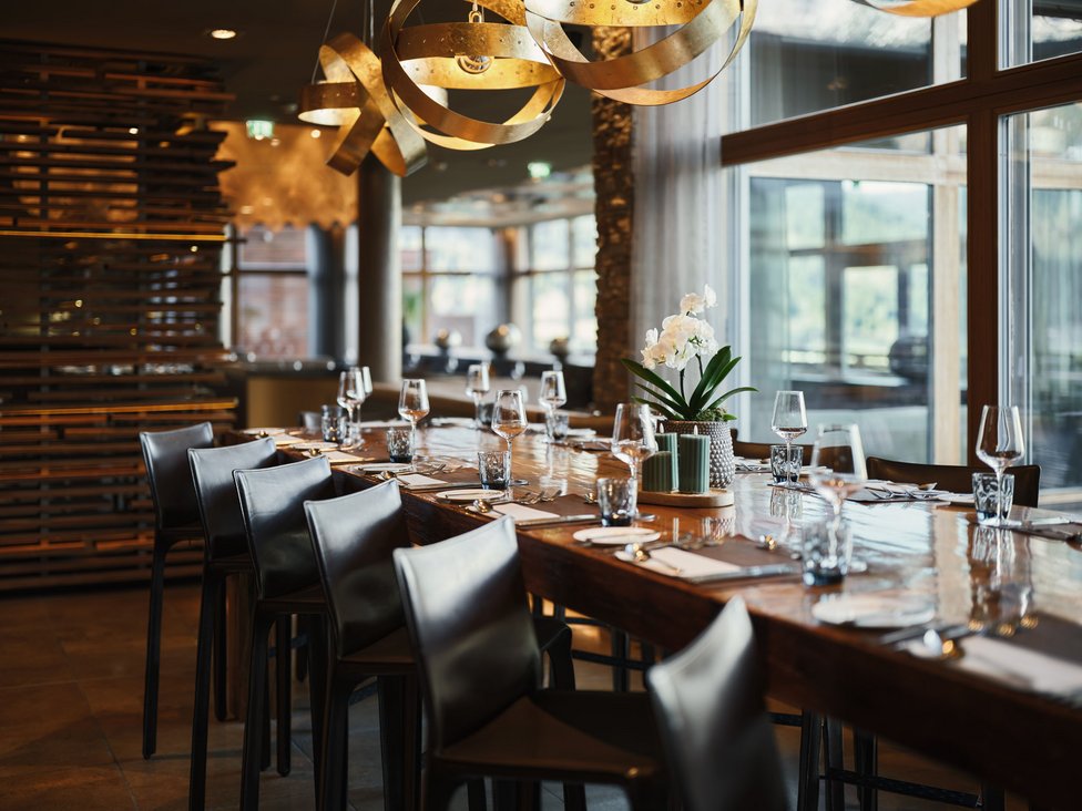 Wellness und Luxus: Ihr Hotel in Tirol Eleganter Esstisch mit Gedeck und moderner Beleuchtung in stilvollem Restaurant