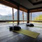 Yoga-Raum mit Blick auf Berge und zwei Matten mit Kissen