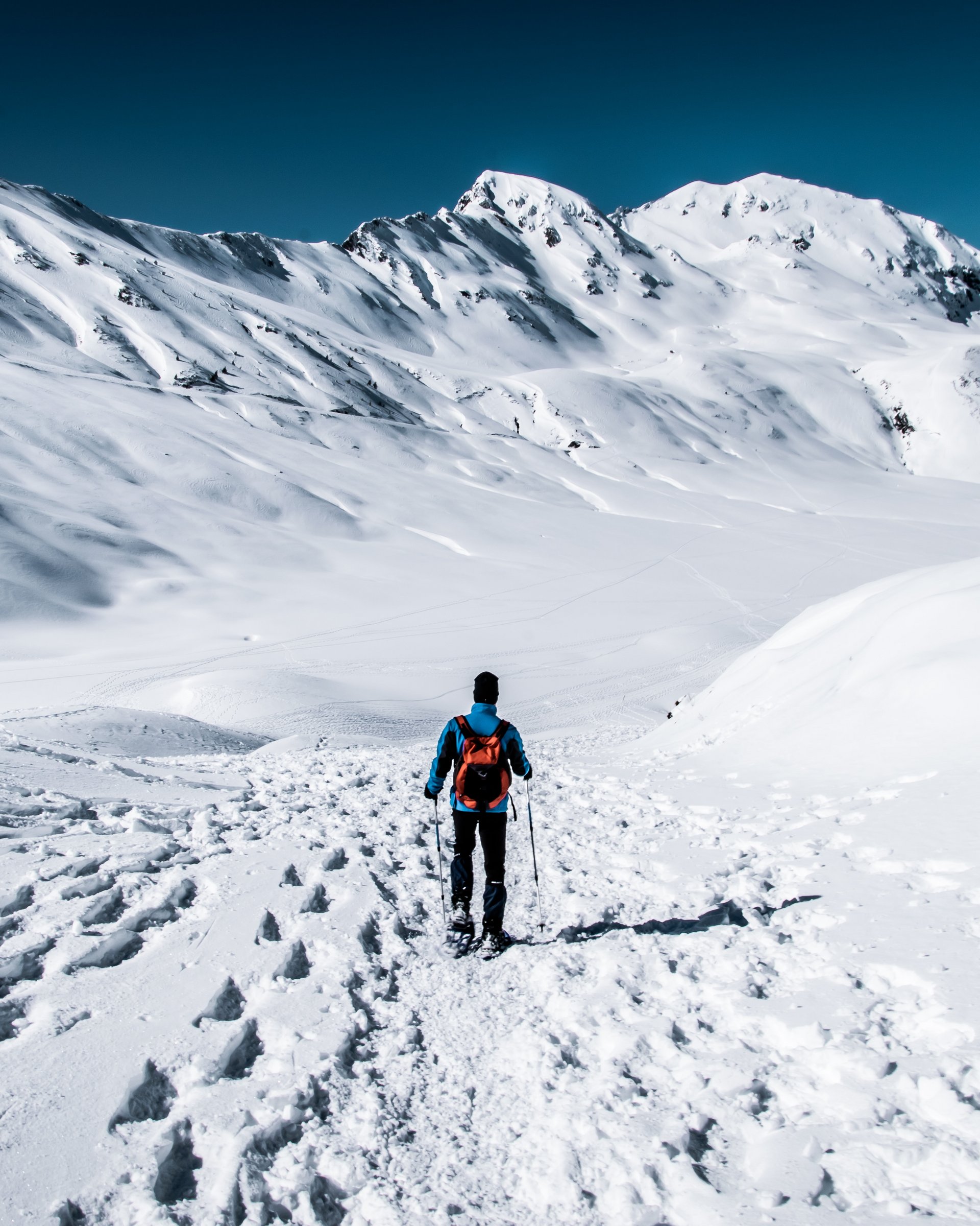 Wunderbares Winterwandern in Lermoos Person wandert im schneebedeckten Gebirge bei klarem Himmel