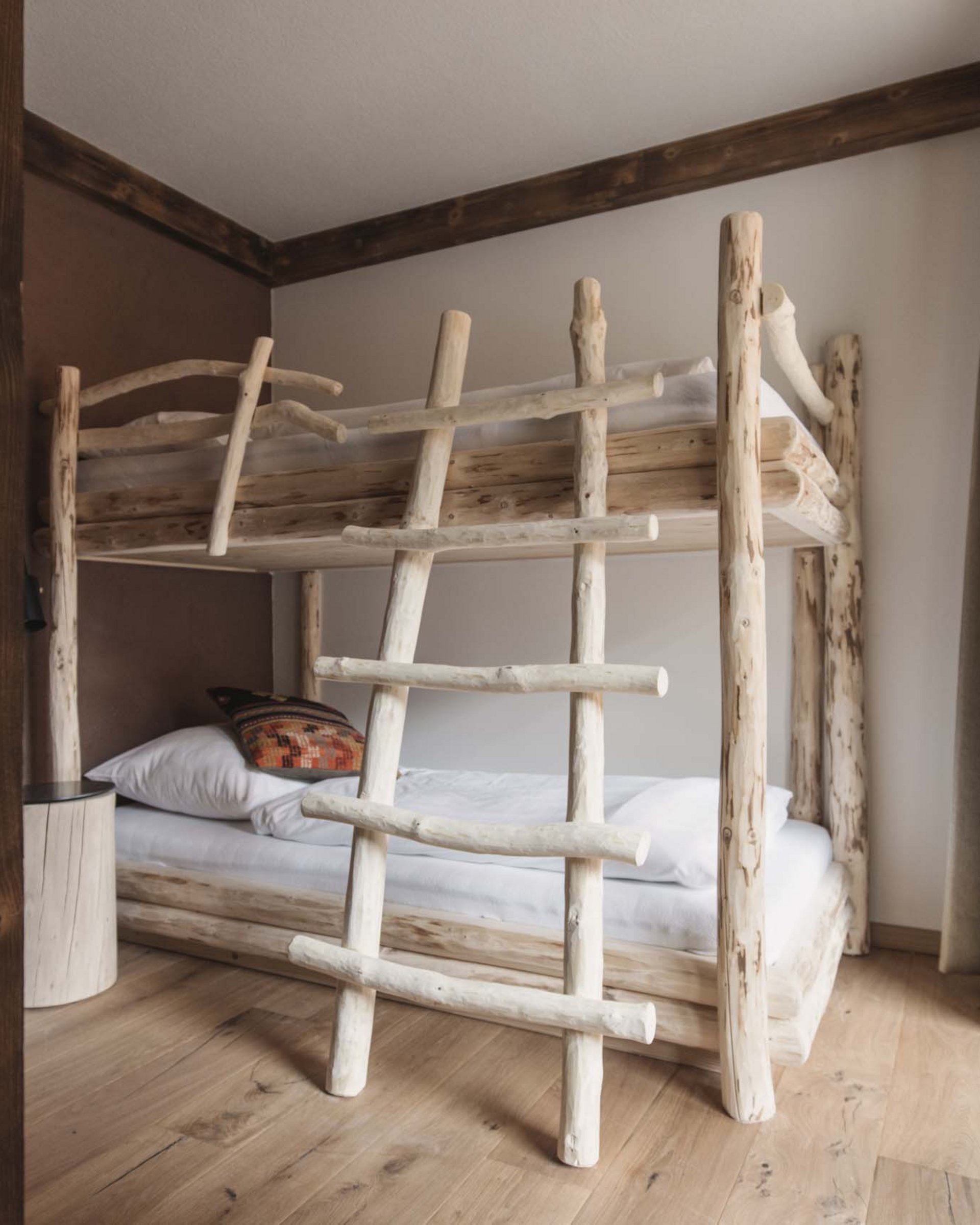 Rustikales Stockbett aus hellem Holz in einem hellen Schlafzimmer