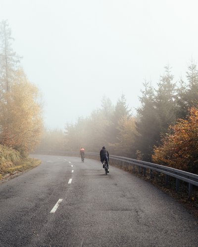 Wellness und Luxus: Ihr Hotel in Tirol Zwei Radfahrer fahren auf einer nebligen Landstraße im Herbst