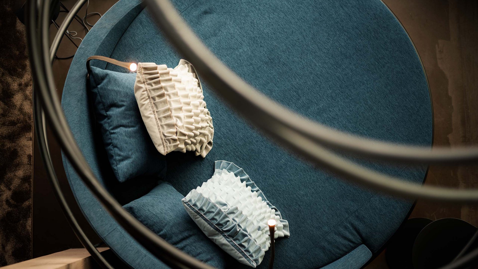 Rundes blaues Sofa mit dekorativen Kissen von oben fotografiert