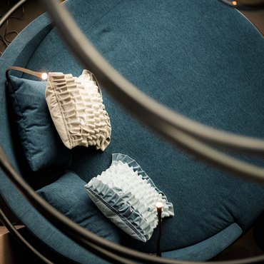 Rundes blaues Sofa mit dekorativen Kissen von oben fotografiert