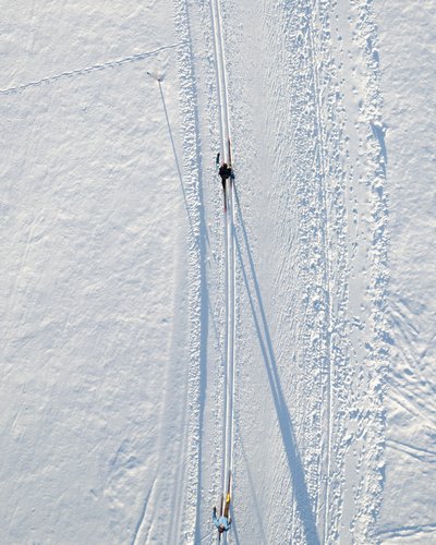 Wellness und Luxus: Ihr Hotel in Tirol Zwei Personen fahren Skilanglauf im frischen Schnee von oben gesehen