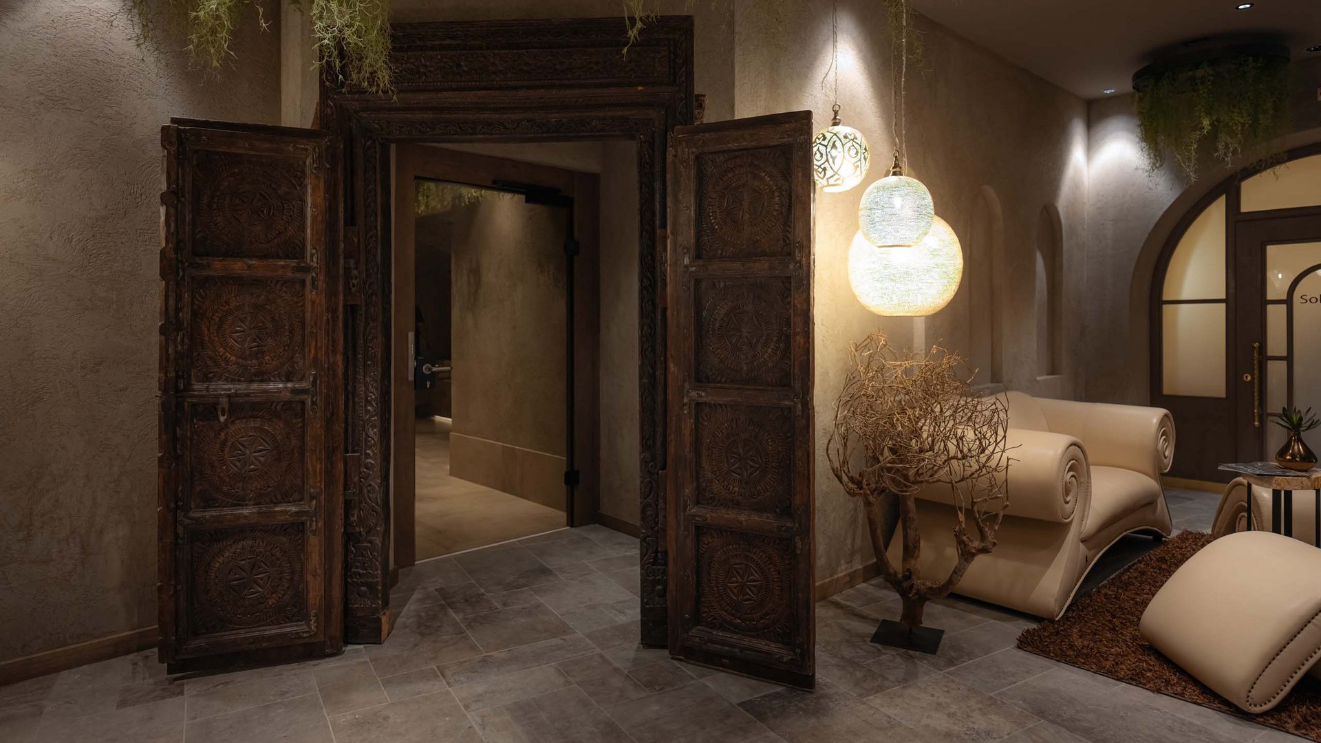 Eleganter Raum mit geschnitzter Holztür und beigen Ledermöbeln