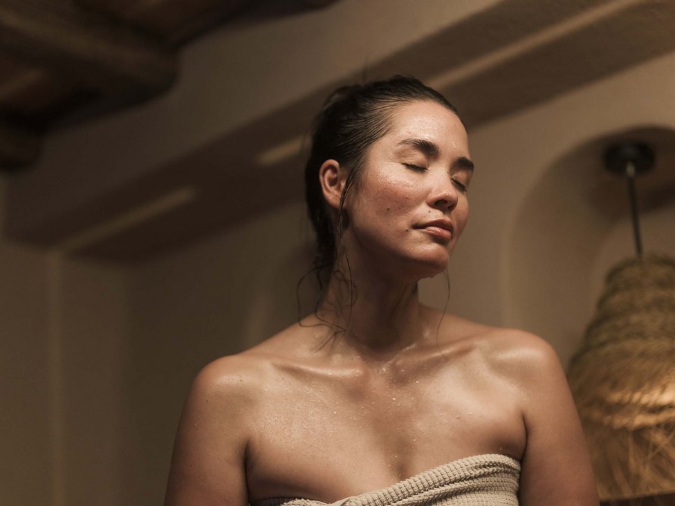 Woman relaxing with eyes closed after shower