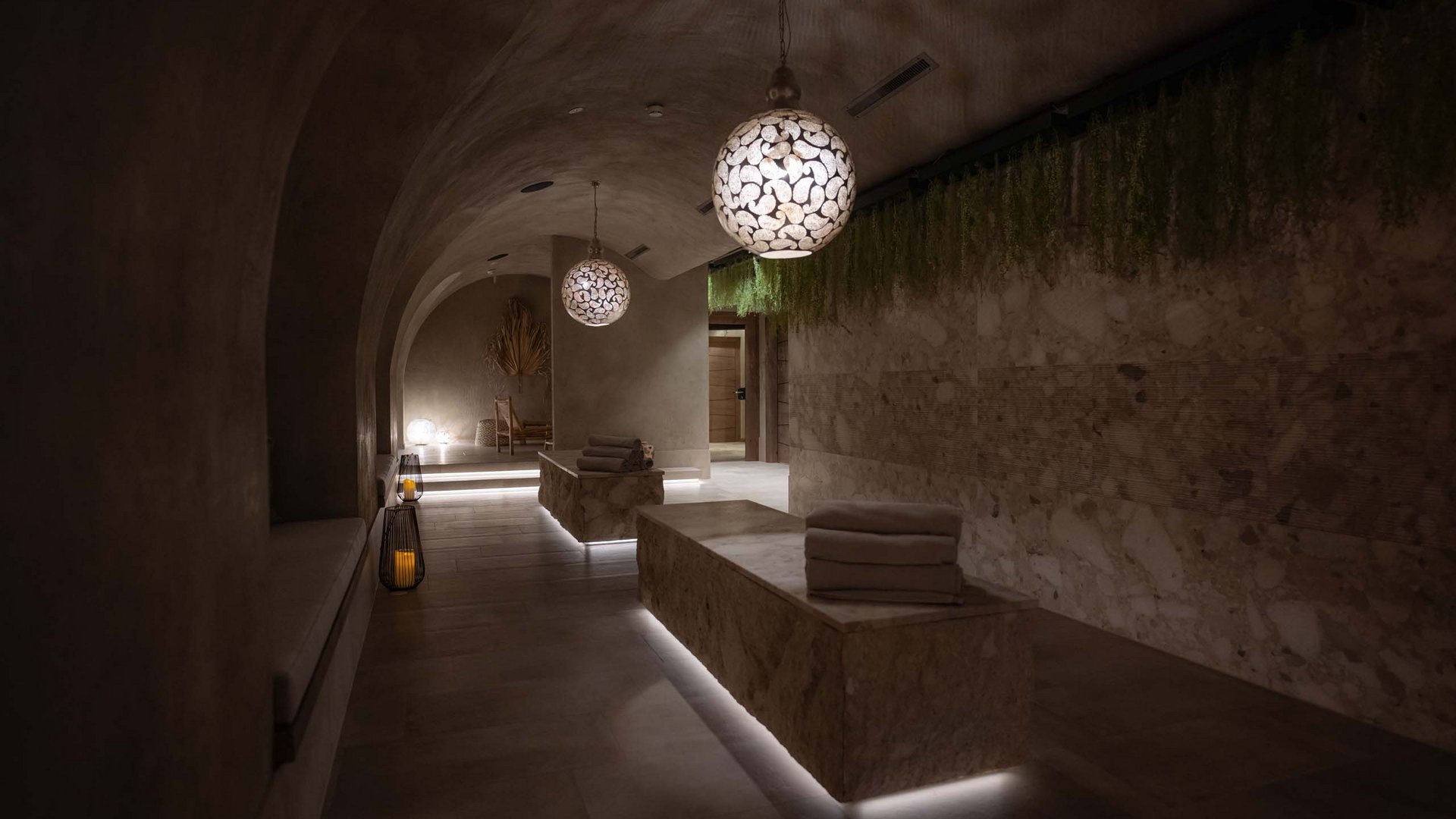 Dunkler Spa-Ruheraum mit modernen Lampen und aufgestapelten Handtüchern