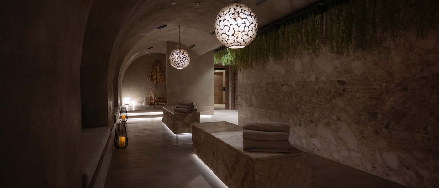 Opening Spa Andalus Dunkler Spa-Ruheraum mit modernen Lampen und aufgestapelten Handtüchern