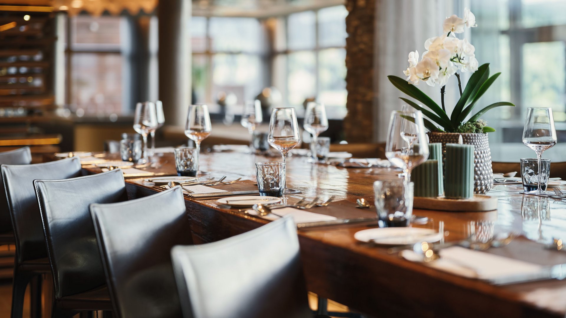 Eleganter Esstisch in modernem Restaurant mit Gläsern und Blumen