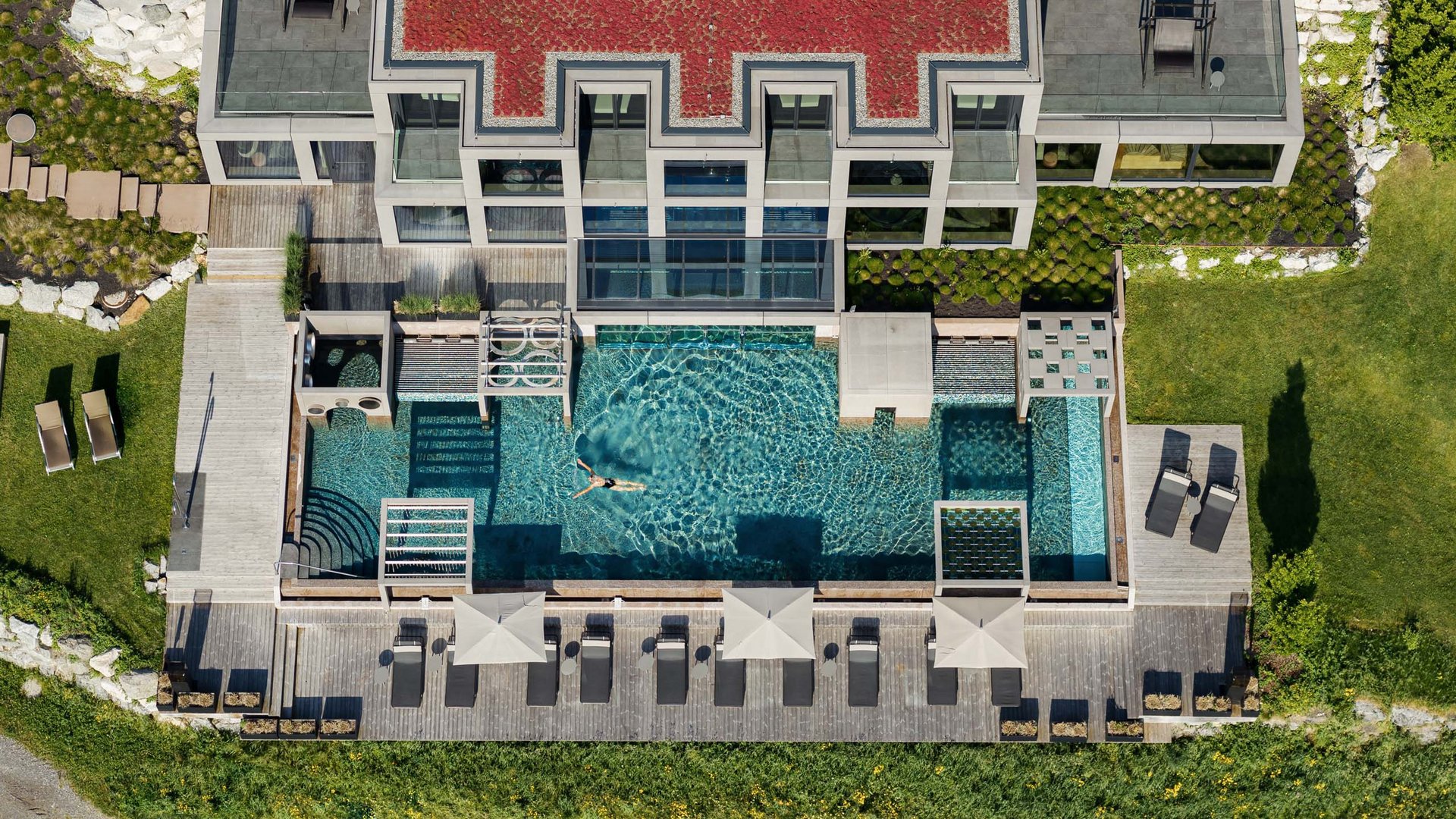 Luftaufnahme eines modernen Hauses mit Pool und Liegestühlen im Garten