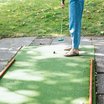 Person spielt Minigolf auf grünem Feld im Freien