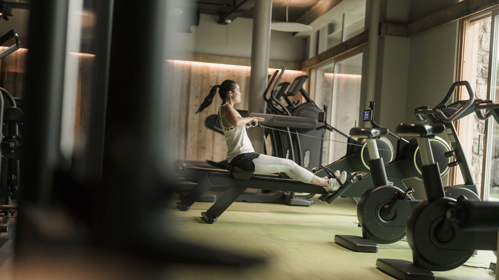 Frau trainiert auf dem Rudergerät im modernen Fitnessstudio