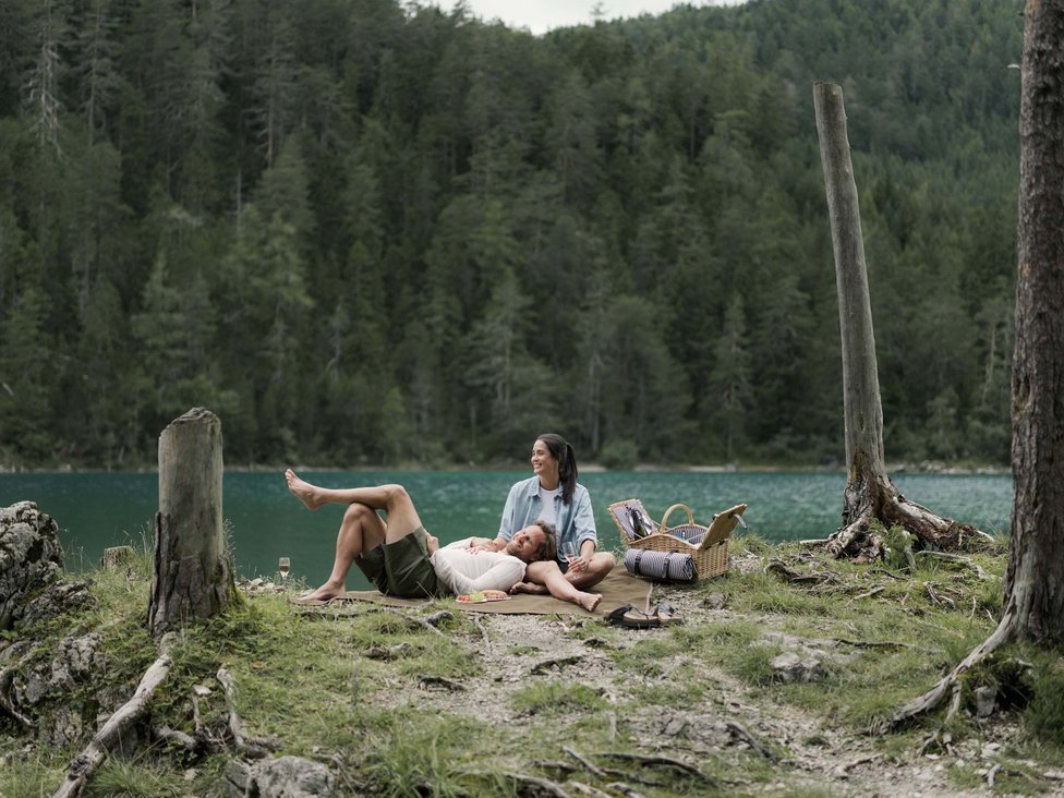 Paar macht Picknick an einem See in einem bewaldeten Gebiet