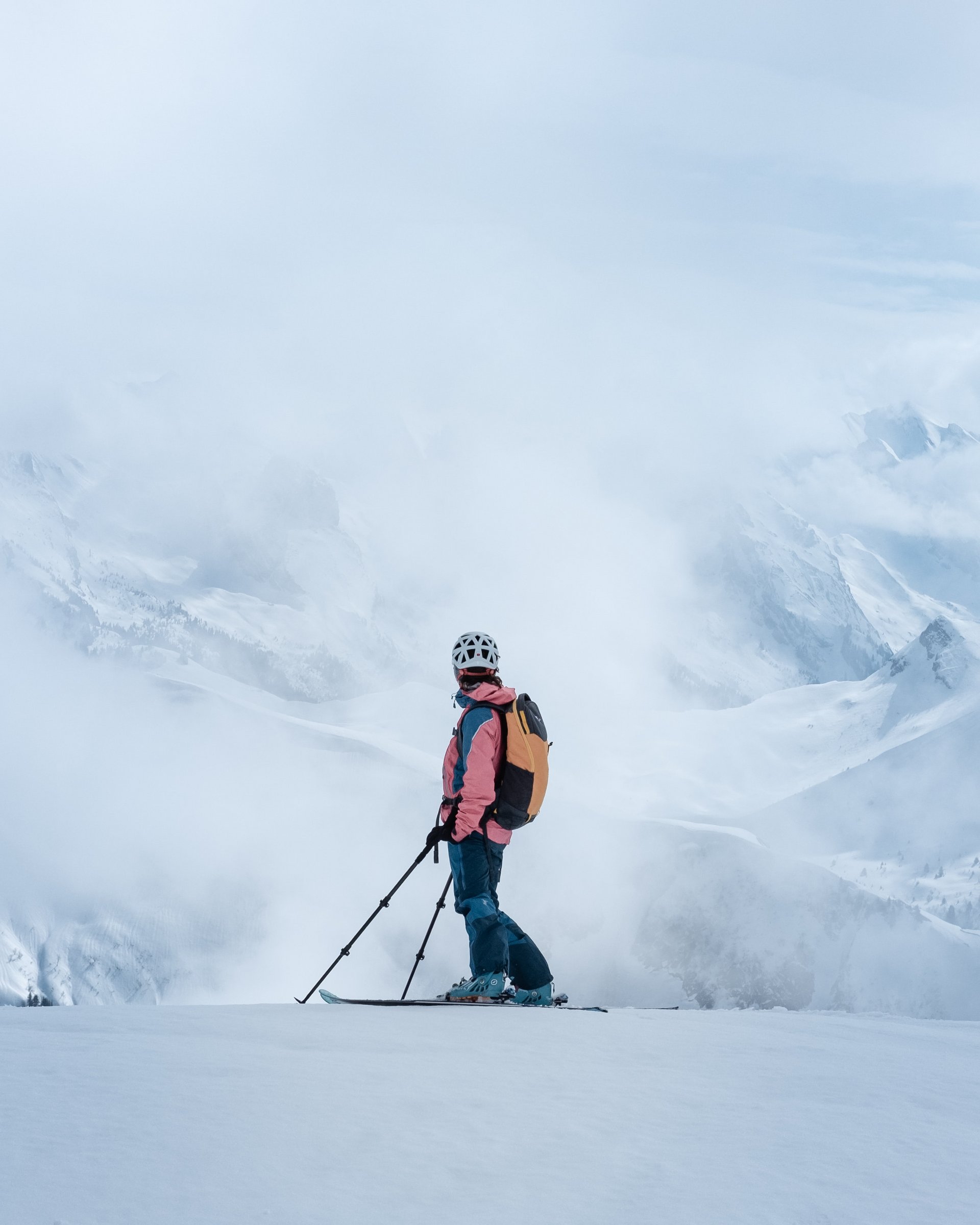 Skifahrer in Berglandschaft umgeben von Nebel und Schnee