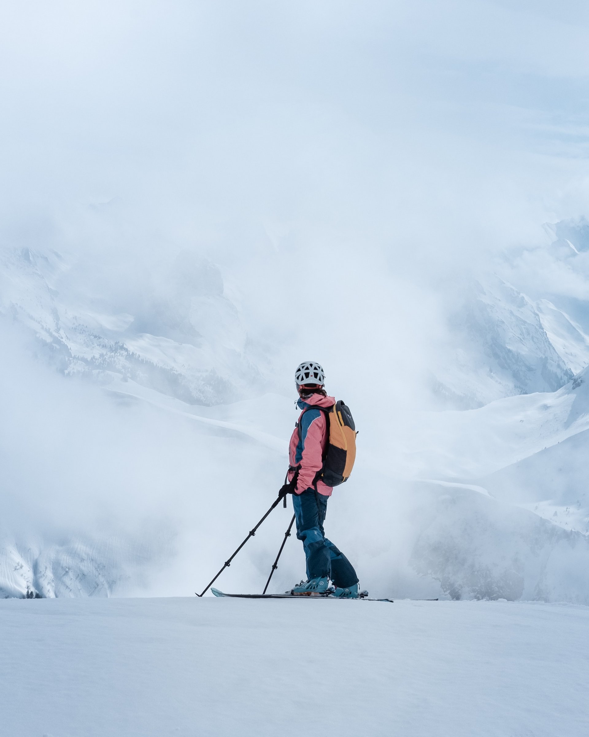 Skifahrer in Berglandschaft umgeben von Nebel und Schnee