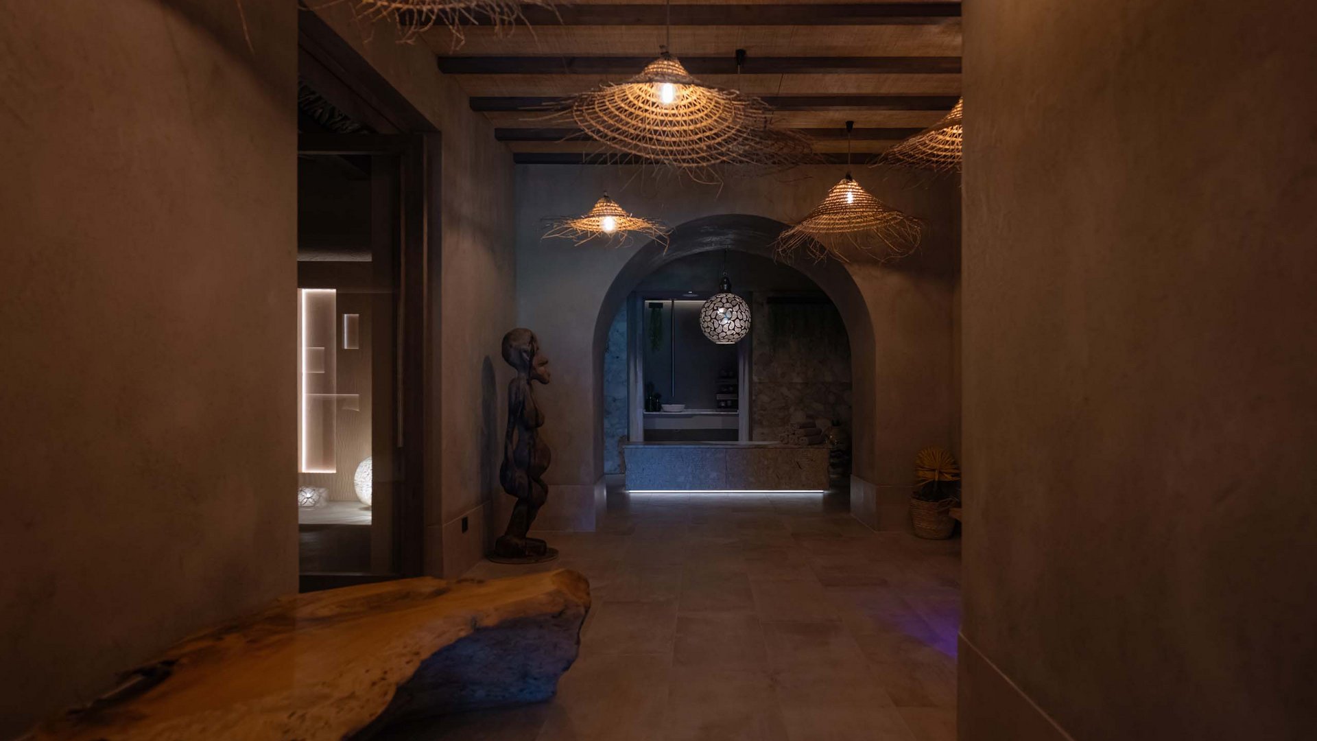 Dunkler Flur mit Holzbank, Skulptur und dekorativen Lampen