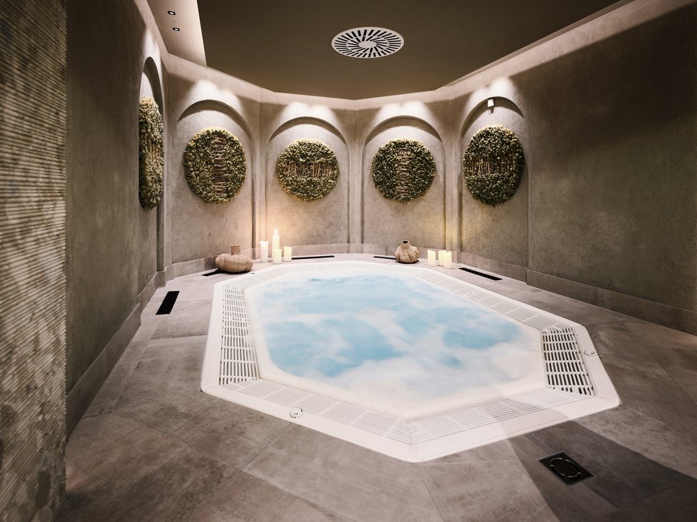 Moderner Whirlpool in entspannendem Spa-Raum mit Kerzen und Wanddekorationen