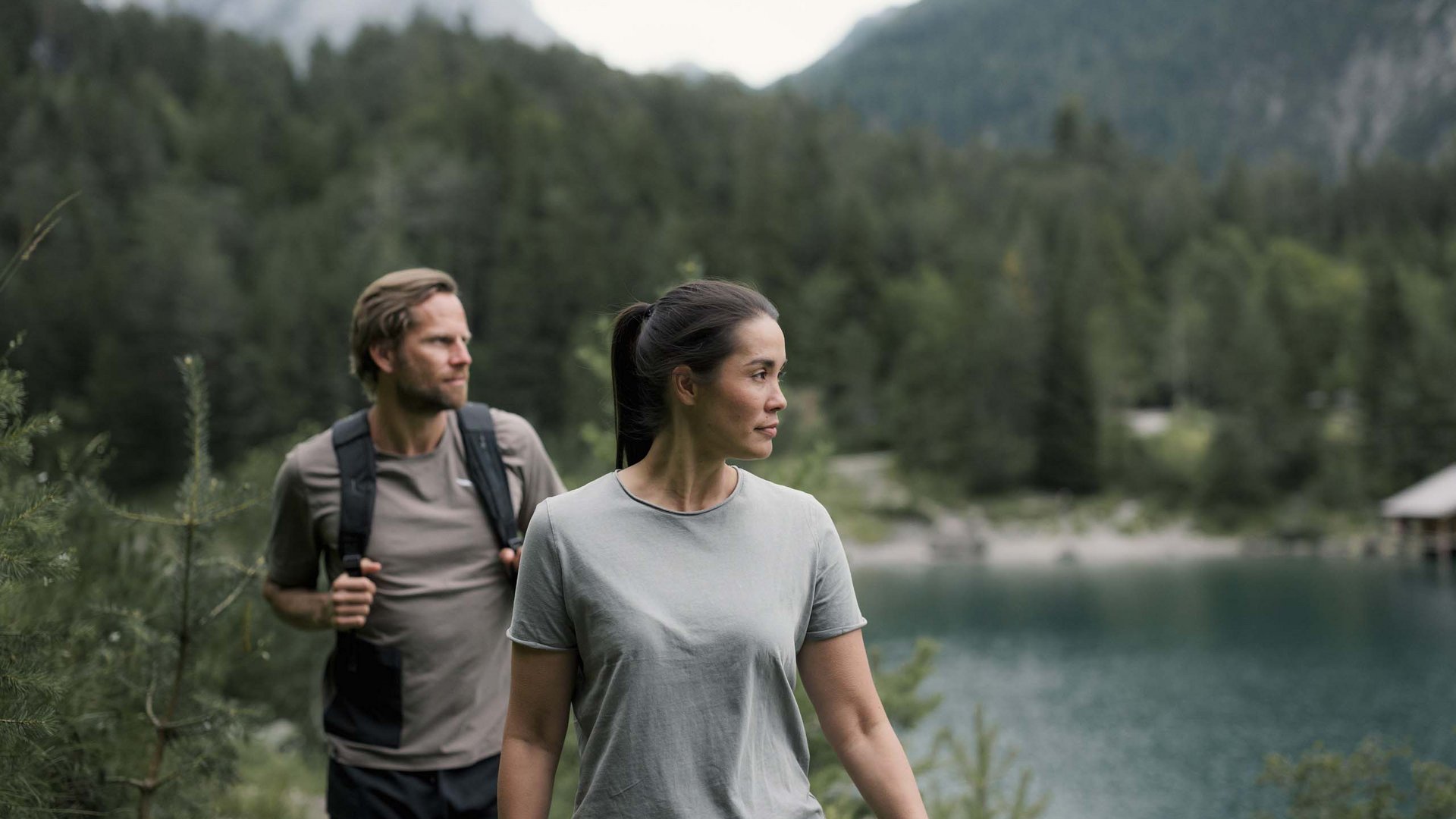 Zwei Wanderer vor Bergsee und Waldlandschaft
