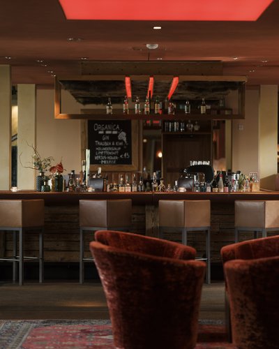 Gemütliche Bar mit Sesseln und Holzmöbeln im warmen Licht